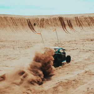 Experience the excitement of off-road dune buggy racing in a sandy desert landscape.